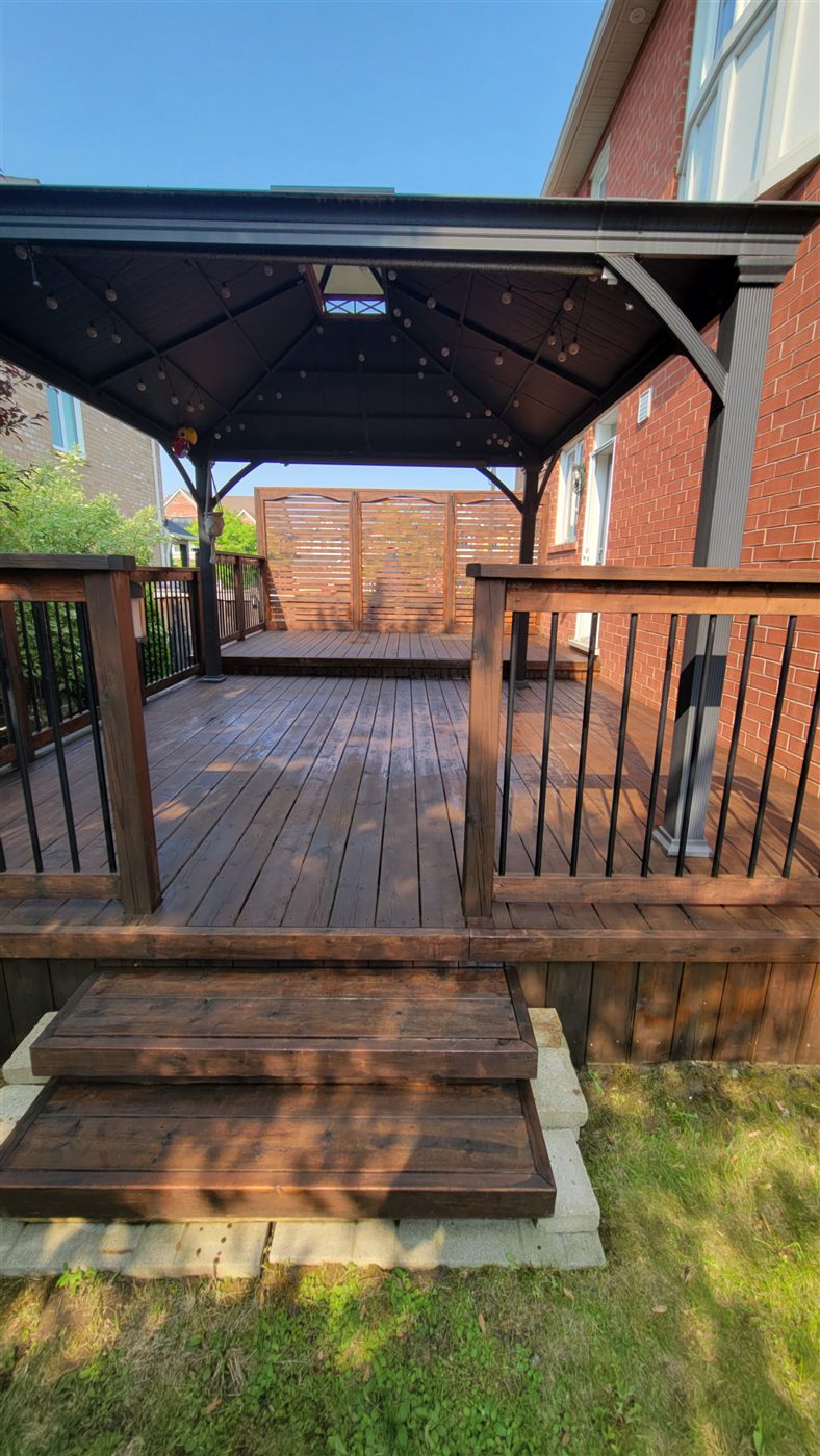 Freshly stained backyard deck with gazebo, railings and steps by VOL Handyman