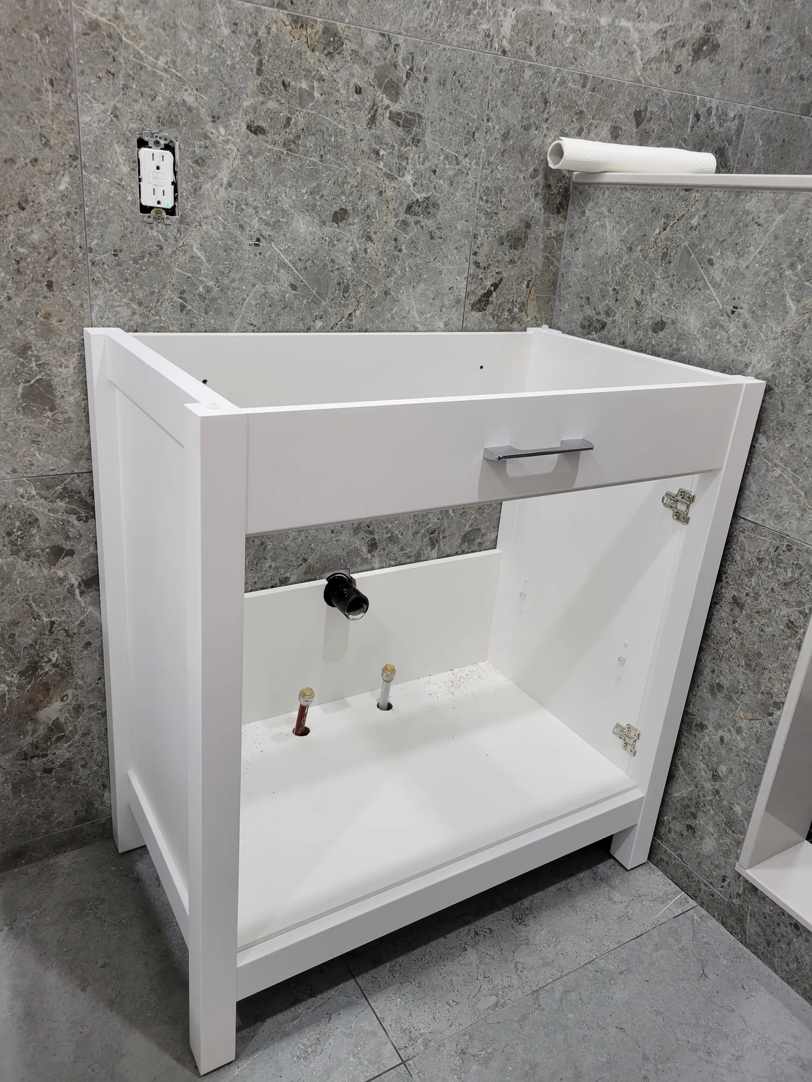 New white shaker floating vanity cabinet mounted before the countertop and sink go in