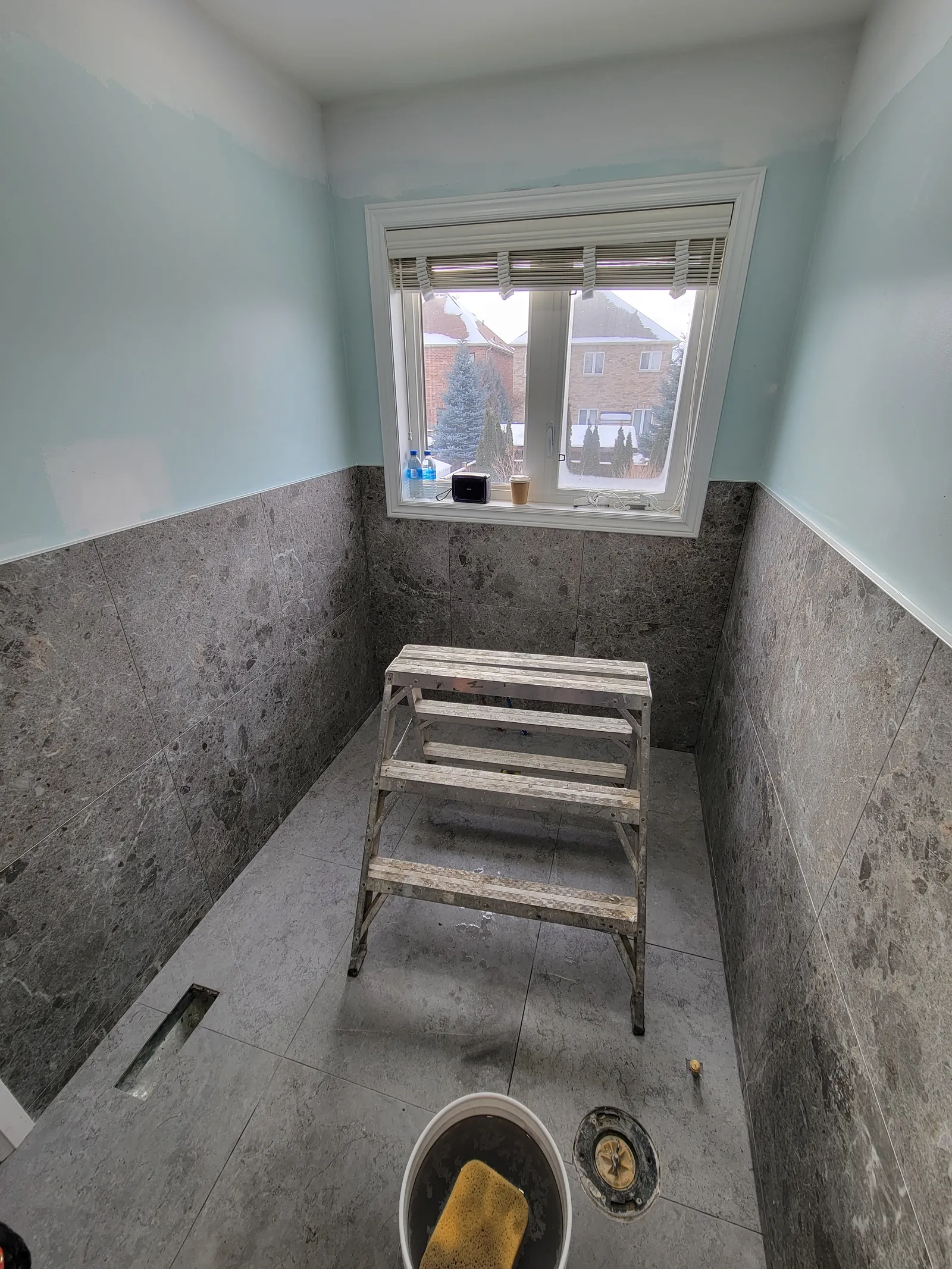 Aurora bathroom fully tiled in grey porcelain with the window trimmed out