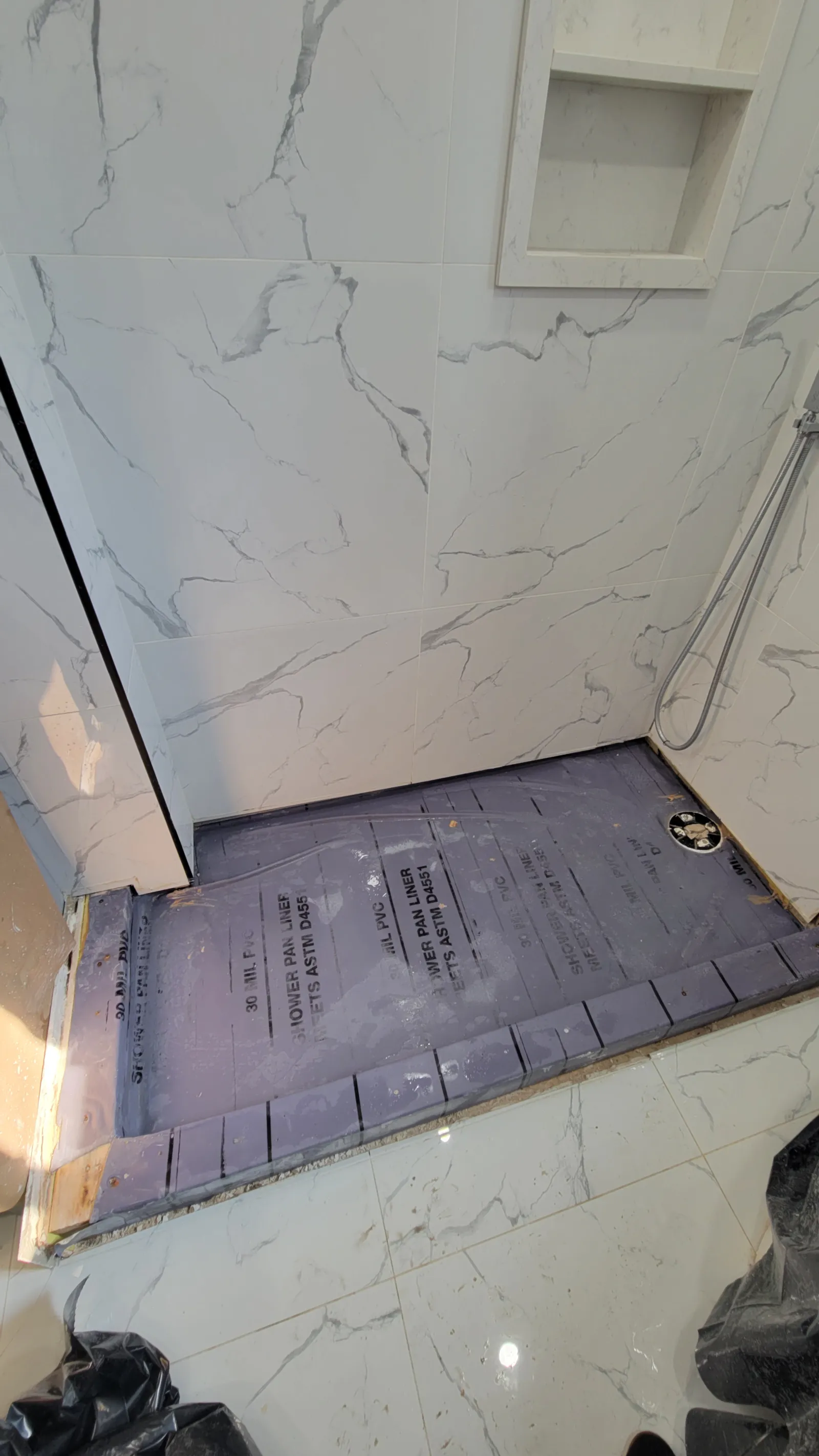 Old shower floor removed in Newmarket exposing the failed PVC pan liner under the tile