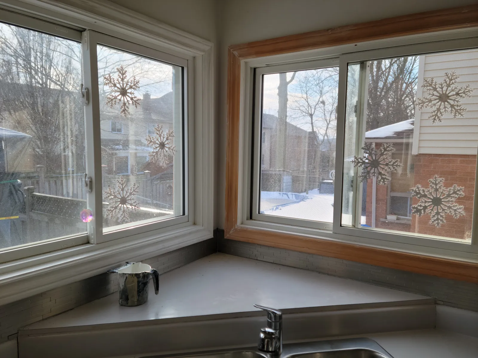 Kitchen window casings in Richmond Hill mid-project, one painted white and one still in bare wood